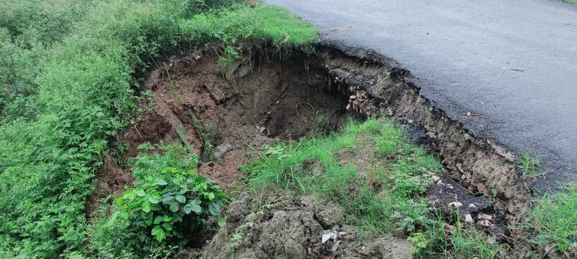 डामर मार्ग की पटरी बरसात के पानी से कटकर बना जानलेवा