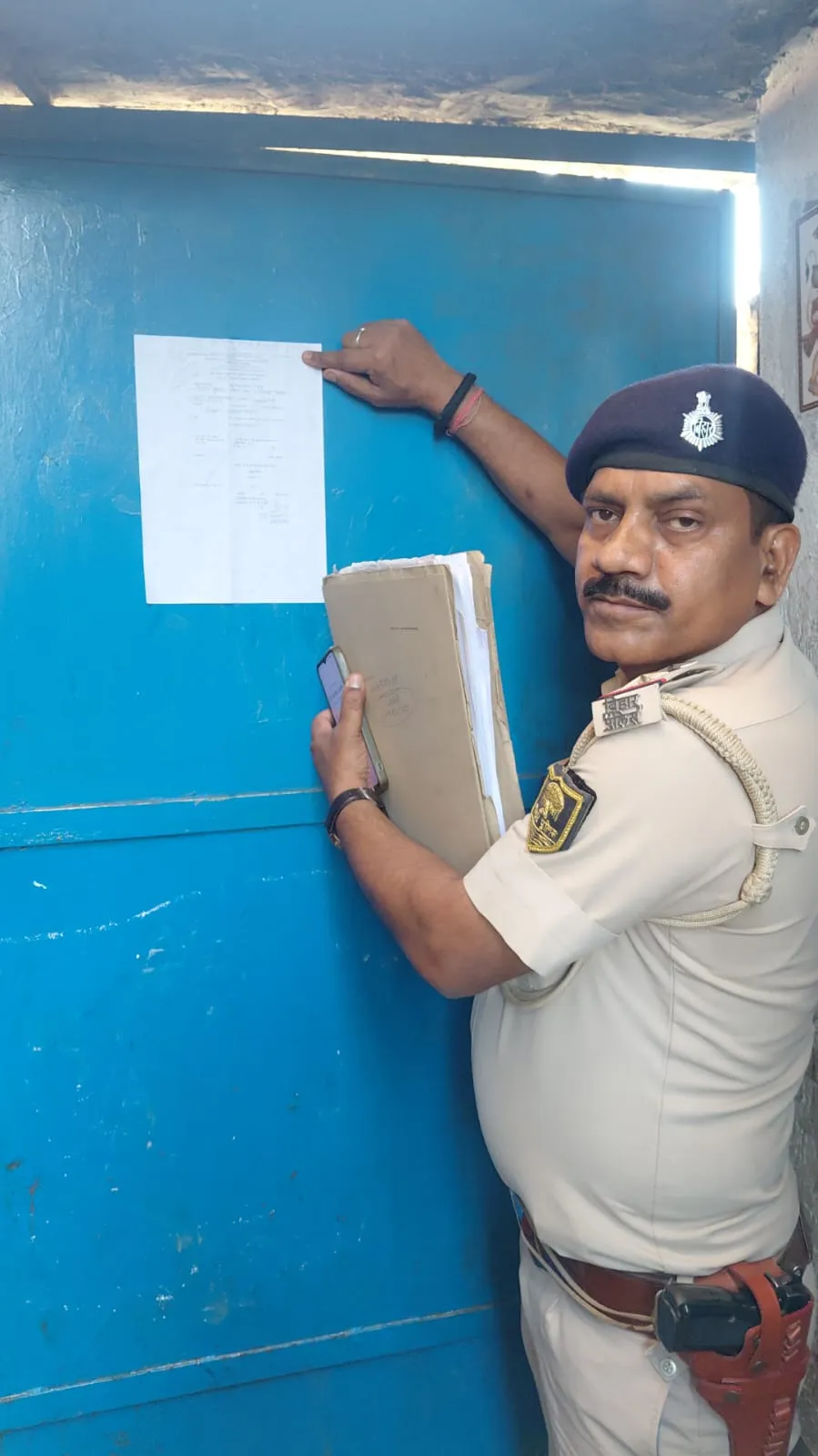 डकैती मामले के फरार अभियुक्त के घर पुलिस ने चिपकाया इश्तिहार