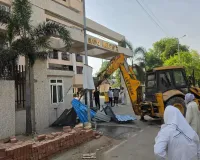 Neo Heights अपार्टमेंट के मुख्य गेट पर चला बुलडोजर, सड़क पर अवैध कब्जा हटाया।