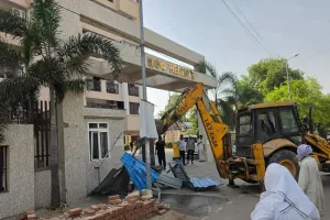 Neo Heights अपार्टमेंट के मुख्य गेट पर चला बुलडोजर, सड़क पर अवैध कब्जा हटाया।